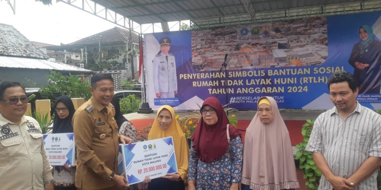 Pj Wali Kota Malang, Wahyu Hidayat menyerahkan secara simbolis bantuan bedah rumah kepada warga Kelurahan Tulusrejo. (Foto/M Sholeh)