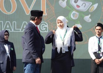 Rektor UIN Malang, Prof. Dr. H.M. Zainuddin, M.A menyematkan jas almamater kepada mahasiswa baru dalam acara pembukaan PBAK UIN Malang 2024. /Foto: dok. UIN Malang.