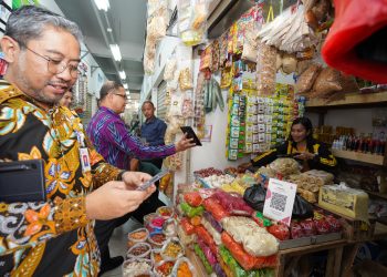 Pj Wali Kota Batu, Aries Agung Paewai, saat mensosialisasikan transaksi QRIS ke pedagang Pasar Induk Among Tani. Foto: Prokopim KWB