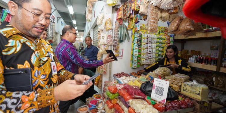 Pj Wali Kota Batu, Aries Agung Paewai, saat mensosialisasikan transaksi QRIS ke pedagang Pasar Induk Among Tani. Foto: Prokopim KWB