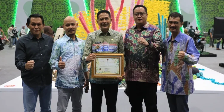 Pj Wali Kota Malang, Wahyu Hidayat, menerima Penghargaan Apresiasi Pembinaan Proklim 2024 dari Menteri LHK RI, Siti Nurbaya Bakar. (Foto/dok. Prokopim Setda Kota Malang)
