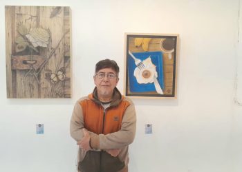 Salah satu pegiat seni Komunitas Tandur, Teguh Nuswantoro berpose bersama karya seni miliknya yang dipamerkan di pameran seni Bhinneka Tunggal Rasa./Foto: Tugumalang.id/Bagus Rachmad Saputra.