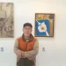 Salah satu pegiat seni Komunitas Tandur, Teguh Nuswantoro berpose bersama karya seni miliknya yang dipamerkan di pameran seni Bhinneka Tunggal Rasa./Foto: Tugumalang.id/Bagus Rachmad Saputra.