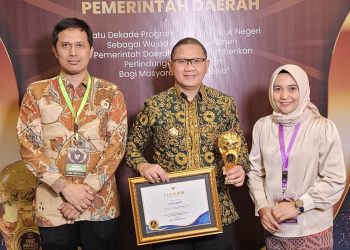 Pj Wali Kota Batu, Aries Agung Paewai, menerima penghargaan UHC Awards kategori utama 2024 untuk Kota Batu. Foto: Prokopim KWB