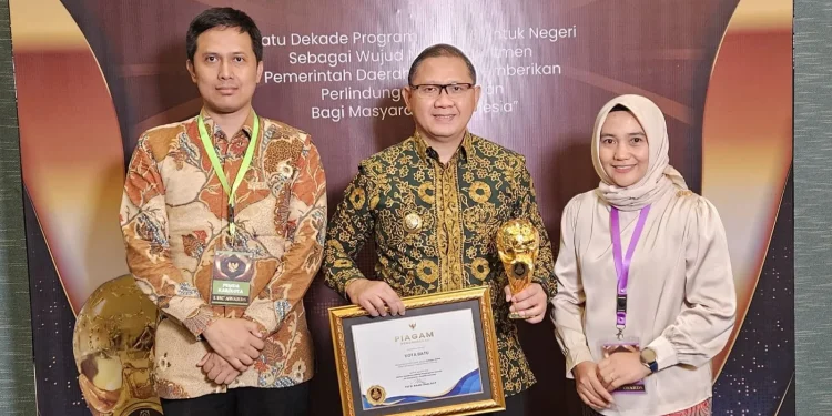 Pj Wali Kota Batu, Aries Agung Paewai, menerima penghargaan UHC Awards kategori utama 2024 untuk Kota Batu. Foto: Prokopim KWB