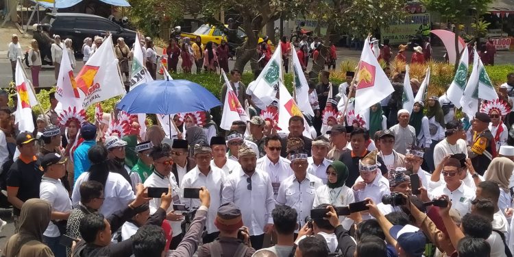 Pasangan Nurochman dan Heli Suyanto diiringi ratusan pendukungnya saat mendaftar ke KPU Kota Batu. Foto: Azmy