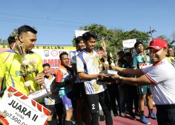 Kapolres Malang, AKBP Putu Kholis Aryana menyerahkan piala kepada pemenang Turnamen Voli Presisi Cup 2024. Foto: Polres Malang
