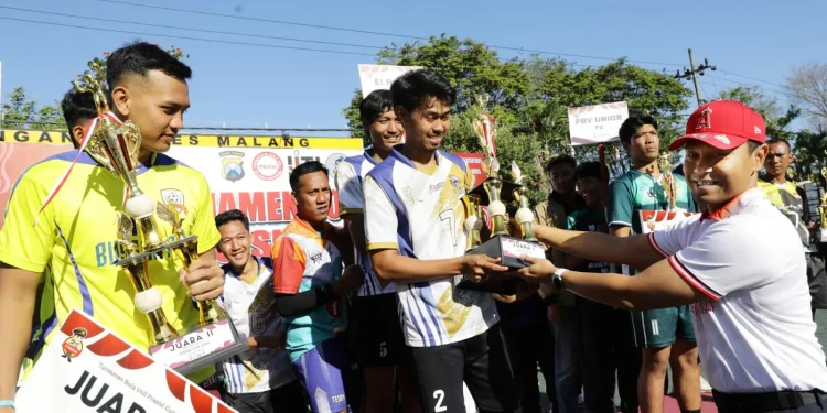Kapolres Malang, AKBP Putu Kholis Aryana menyerahkan piala kepada pemenang Turnamen Voli Presisi Cup 2024. Foto: Polres Malang