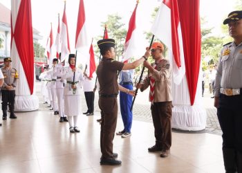 Pj Wali Kota Batu, Aries Agung Paewai, membagikan bendera merah putih untuk target mengibarkan 7.900 bendera di Kota Batu selama HUT RI ke-79. Foto: Prokopim KWB