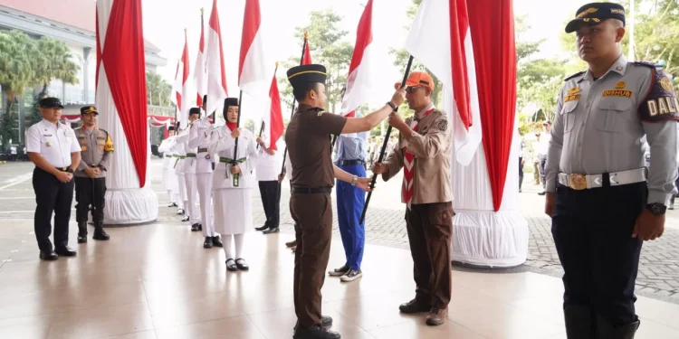 Pj Wali Kota Batu, Aries Agung Paewai, membagikan bendera merah putih untuk target mengibarkan 7.900 bendera di Kota Batu selama HUT RI ke-79. Foto: Prokopim KWB