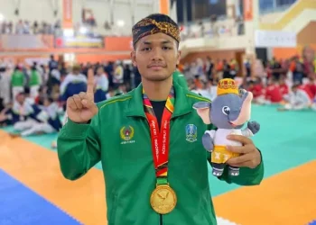 Aryo Pandu Pamungkas, atlet Kota Batu, memamerkan medali emas yang baru saja ia peroleh di PON 2024. Foto: KONI Kota Batu