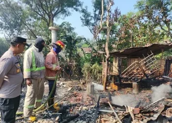 Petugas melakukan pembasahan di puing-puing kandang kambing yang habis terbakar. Foto: Polsek Wonosari