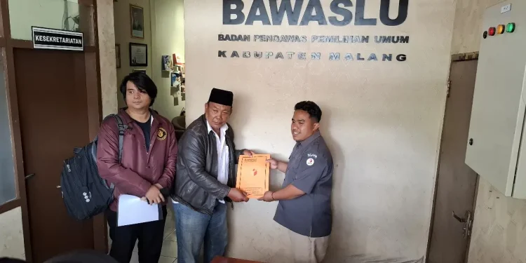 Ketua Tim Bidang Hukum Paslon Gus, Suwito Wijoyo menyerahkan berkas laporan ke Bawaslu Kabupaten Malang. Foto: Aisyah Nawangsari Putri