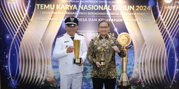Kepala Desa Tulungrejo bersama Pj Wali Kota usai meraih penghargaan Desa Terbaik I Nasional. Foto: Prokopim KWB