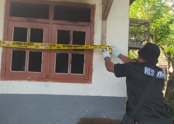 Petugas memasang garis polisi di TKP adik bakar kakak di Tirtoyudo. Foto: Polres Malang