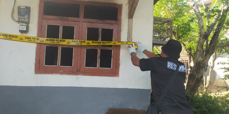 Petugas memasang garis polisi di TKP adik bakar kakak di Tirtoyudo. Foto: Polres Malang