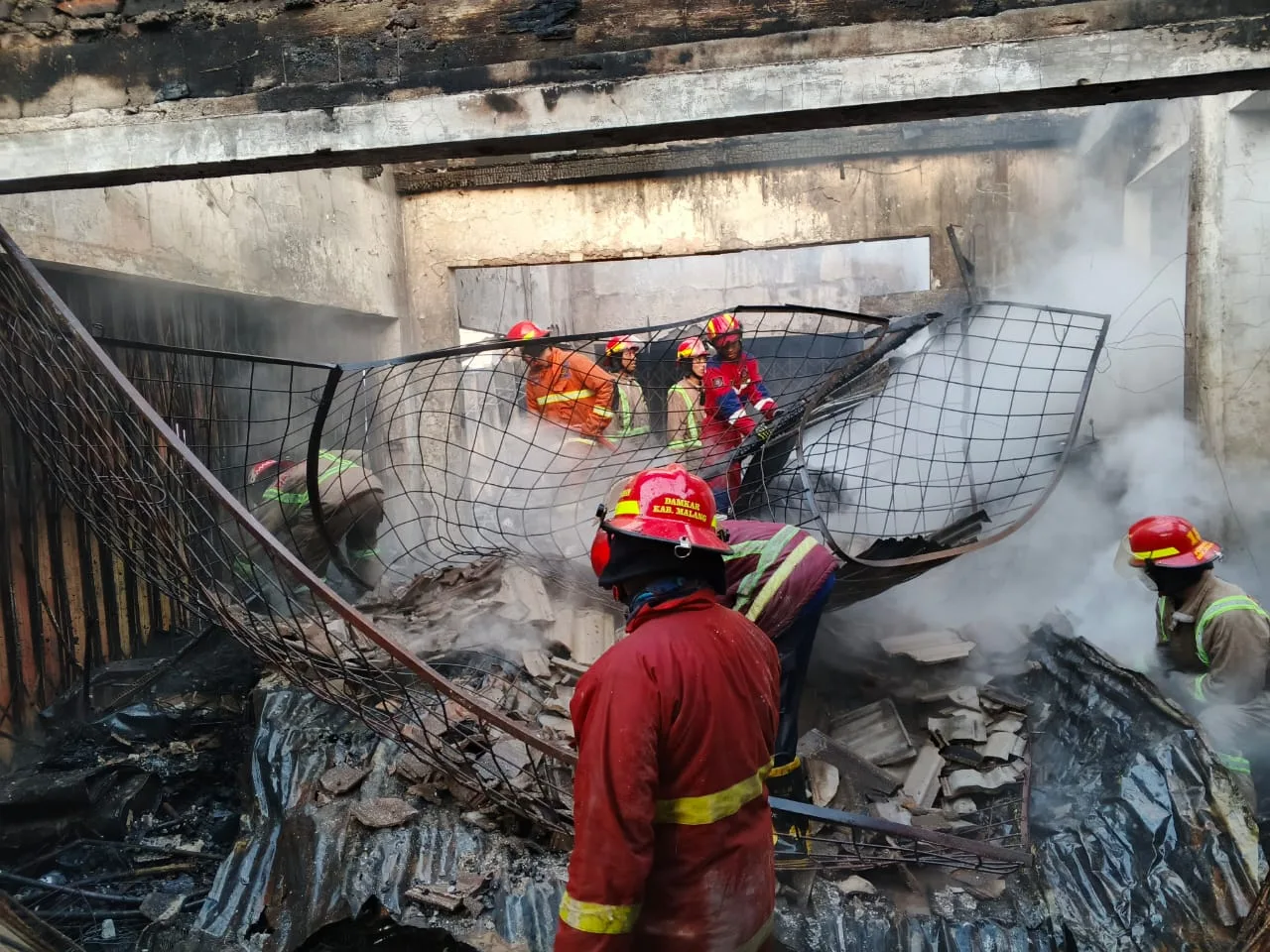 Petugas damkar melakukan pembasahan usai api padam. Foto: Damkar Kabupaten Malang