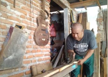 Muhammad Fauzi Labas Gitar Malang saat saat mengolah kayu mahoni menjadi fretboard gitar. Foto/dok