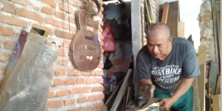 Muhammad Fauzi Labas Gitar Malang saat saat mengolah kayu mahoni menjadi fretboard gitar. Foto/dok