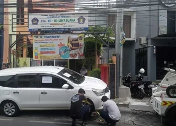 Petugas menderek mobil yang parkir sembarangan hingga menutup akses sekolah. (Foto/Ist)