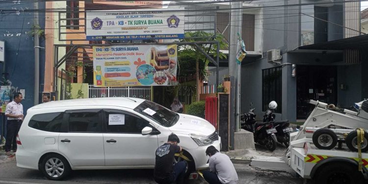 Petugas menderek mobil yang parkir sembarangan hingga menutup akses sekolah. (Foto/Ist)