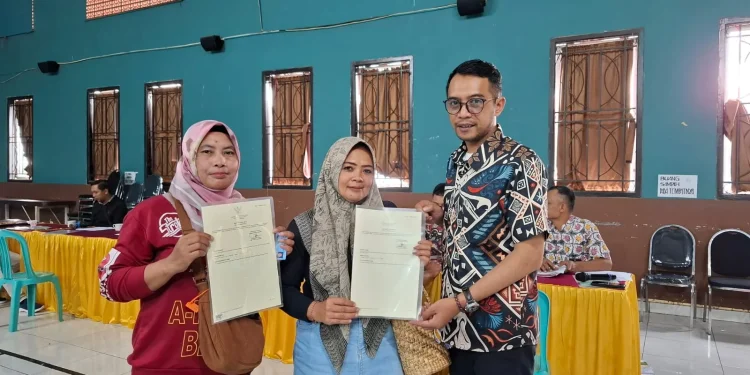 Kepala Desa Bulukerto, Suhermawan, saat menyerahkan sertifikat PTSL kepada warga. Foto: Azmy
