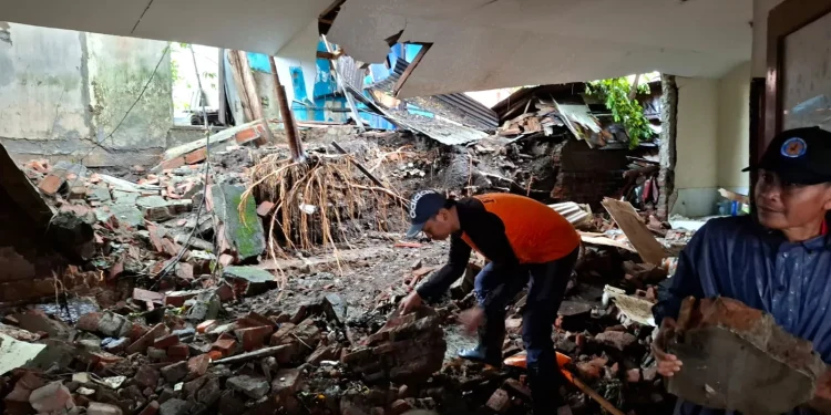 Penanganan cepat petugas BPBD Kota Batu membersihkan sisa reruntuhan tembok yang ambrol di gedung Kelurahan Sisir Kota Batu. Foto: Azmy