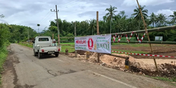 Warga memasang spanduk penolakan di lokasi Baqi Memorial Park. Foto: Aisyah Nawangsari Putri