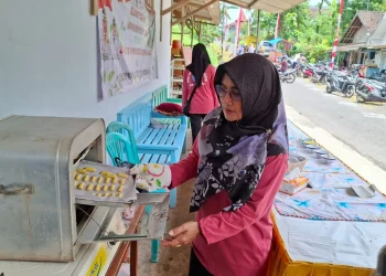 Ketua Pokja 3 PKK Desa Ternyang, Srianingsih memanggang kue kering daun kelor. Foto: Aisyah Nawangsari Putri