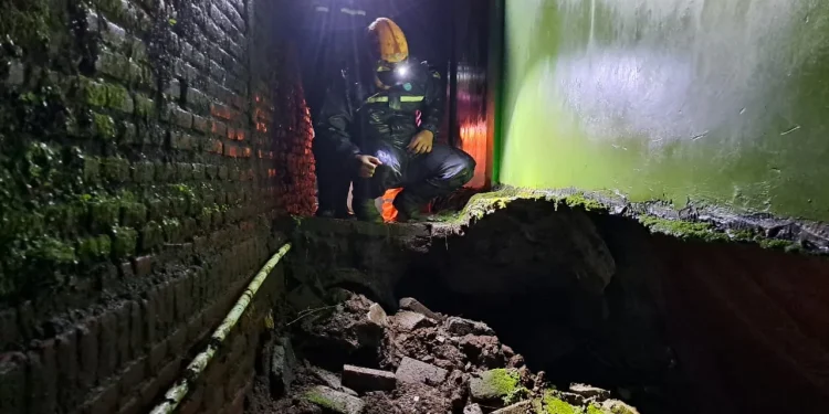 Penanganan petugas pasca kejadian tanah amnles yang membuat tembok pagar SDN Tulungrejo roboh. Foto: BPBD Kota Batu