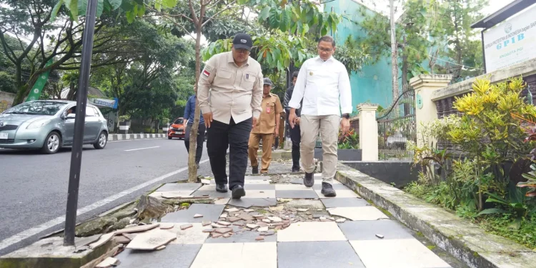 Pj Wali Kota Batu bersama Kepala Dinas PUPR meninjau kondisi pedestrian yang sudah rusak di Jalan Trunojoyo. Foto: Prokopim KWB