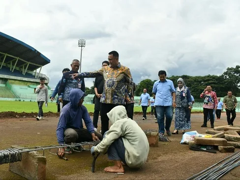 Pj Wali Kota Malang, Iwan Kurniawan meninjau proses perbaikan lintasan atletik di Stadion Gajayana. (Foto/M Sholeh)