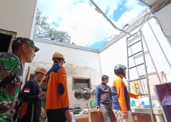 Petugas BPBD Kota Batu saat melakukan asesmen kerusakan atap rumah warga akibat angin kencang. Foto: BPBD Kota Batu