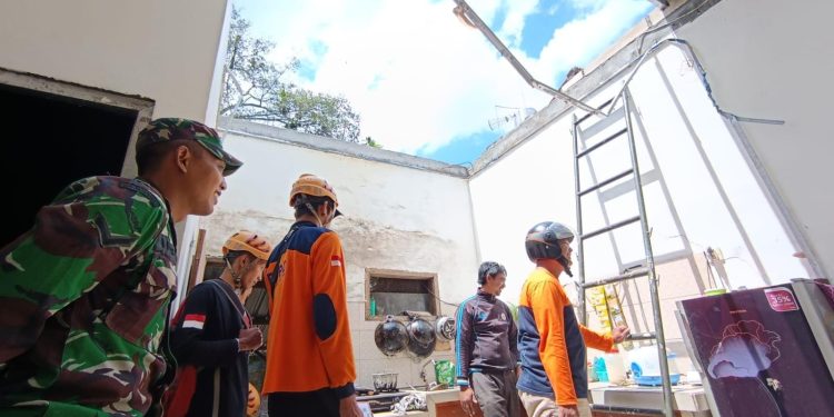 Petugas BPBD Kota Batu saat melakukan asesmen kerusakan atap rumah warga akibat angin kencang. Foto: BPBD Kota Batu