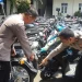 Kasat Lantas Polresta Malang Kota, Kompol Agung Fitransyah menunjukkan ratusan motor milik pelaku balap liar. (Foto/M Sholeh)