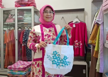 Eva menunjukkan produk tas yang terbuat dari kain perca dengan aksen bordir. Foto: Aisyah Nawangsari Putri