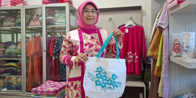 Eva menunjukkan produk tas yang terbuat dari kain perca dengan aksen bordir. Foto: Aisyah Nawangsari Putri