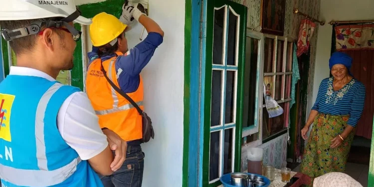 Senyum Patemi, tukang pijat penerima program Light Up The Dream dari PLN UP3 Malang merekah saat petugas memasang jaringan listrik di rumahnya. (Foto/dok.)