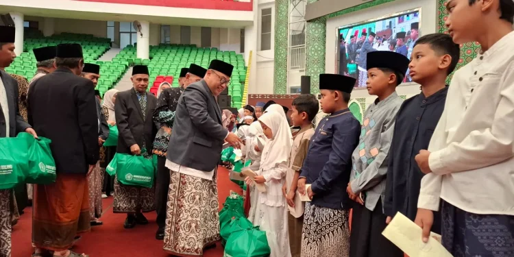 Rektor Unisma Prof Djunaidi saat memberikan santunan kepada anak yatim. Foto: Azmy