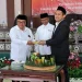 Dekan FH Unisma Arfan Kaimudin memberikan potongan tumpeng tasyakuran kepada Rektor Unisma Prof Junaidi. Foto: Azmy