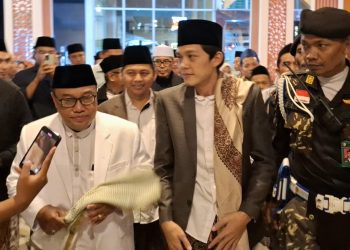 Rektor Unisma Prof Junaidi saat mendampingi Gus Iqdam naik ke podium Unisma Bershalawat. Foto: Azmy