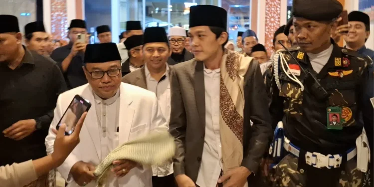 Rektor Unisma Prof Junaidi saat mendampingi Gus Iqdam naik ke podium Unisma Bershalawat. Foto: Azmy