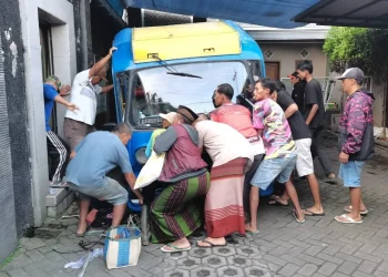 Proses evakuasi mengeluarkan badan montir yang tertimpa kendaraan. Foto: Polres Batu