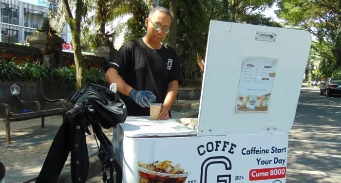 Salah satu barista kopi keliling yang sering mangkal di Jalan Veteran Kota Malang. /Foto: Tugumalang.id/Bagus Rachmad Saputra.