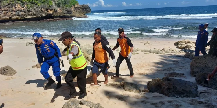 Petugas mengevakuasi jenazah nelayan yang tewas terhempas ombak di perairan Kondangmerak. Foto: Polres Malang