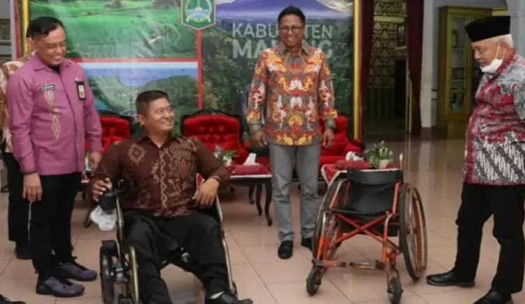Ketua NPCI Kabupaten Malang, Yulian Agung menerima kursi roda elektrik dari CSR PT Bentoel. Foto: Pemkab Malang