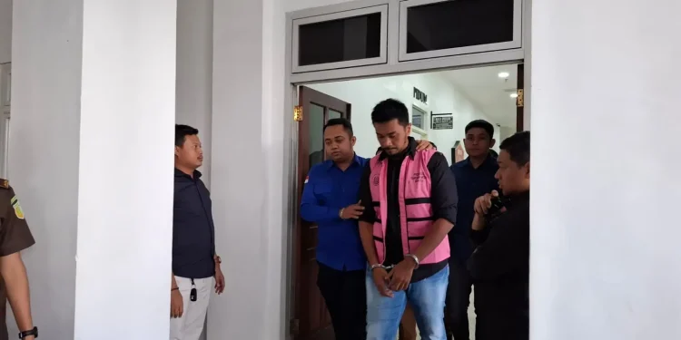 Salah satu pegawai BRI tersangka KUR fiktif saat digelandang petugas Kejari Batu. Foto: Azmy