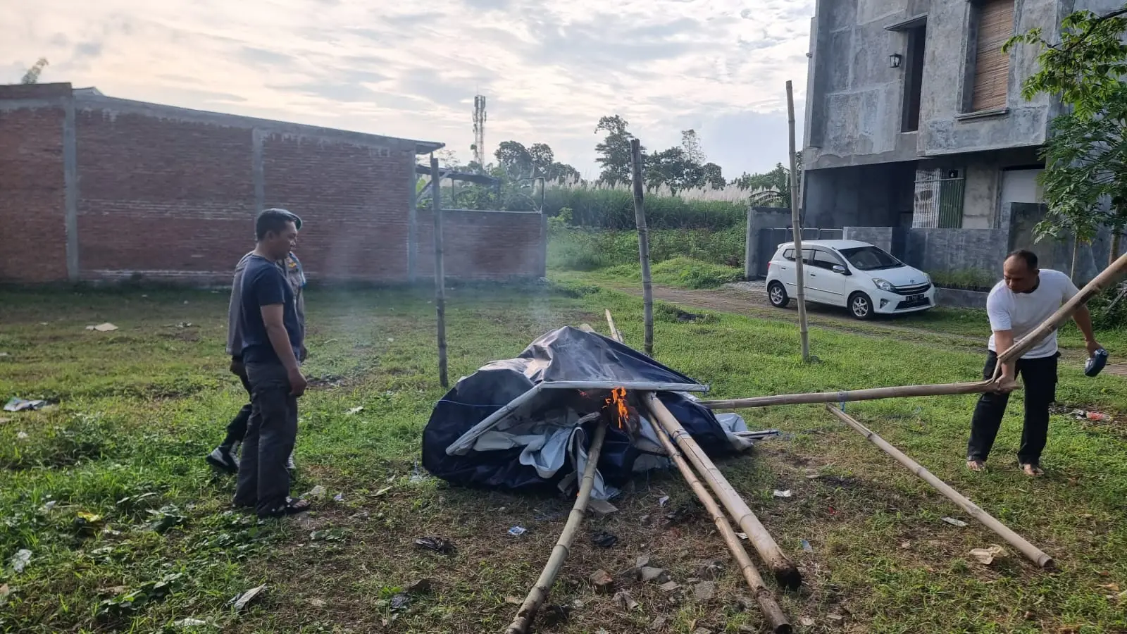 Petugas membakar bambu dan terpal yang diduga digunakan untuk judi sabung ayam. Foto: Polres Malang