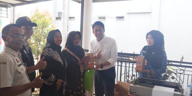 Kepala Bapenda Kabupaten Malang, Made Arya Wedanthara (baju putih) menyerahkan dorprize untuk masyarakat yang memanfaatkan layanan Bapenda Menyapa Warga. (Foto/M Sholeh)