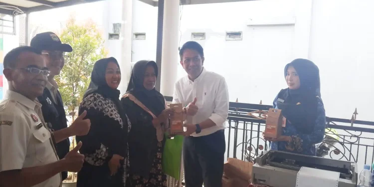 Kepala Bapenda Kabupaten Malang, Made Arya Wedanthara (baju putih) menyerahkan dorprize untuk masyarakat yang memanfaatkan layanan Bapenda Menyapa Warga. (Foto/M Sholeh)